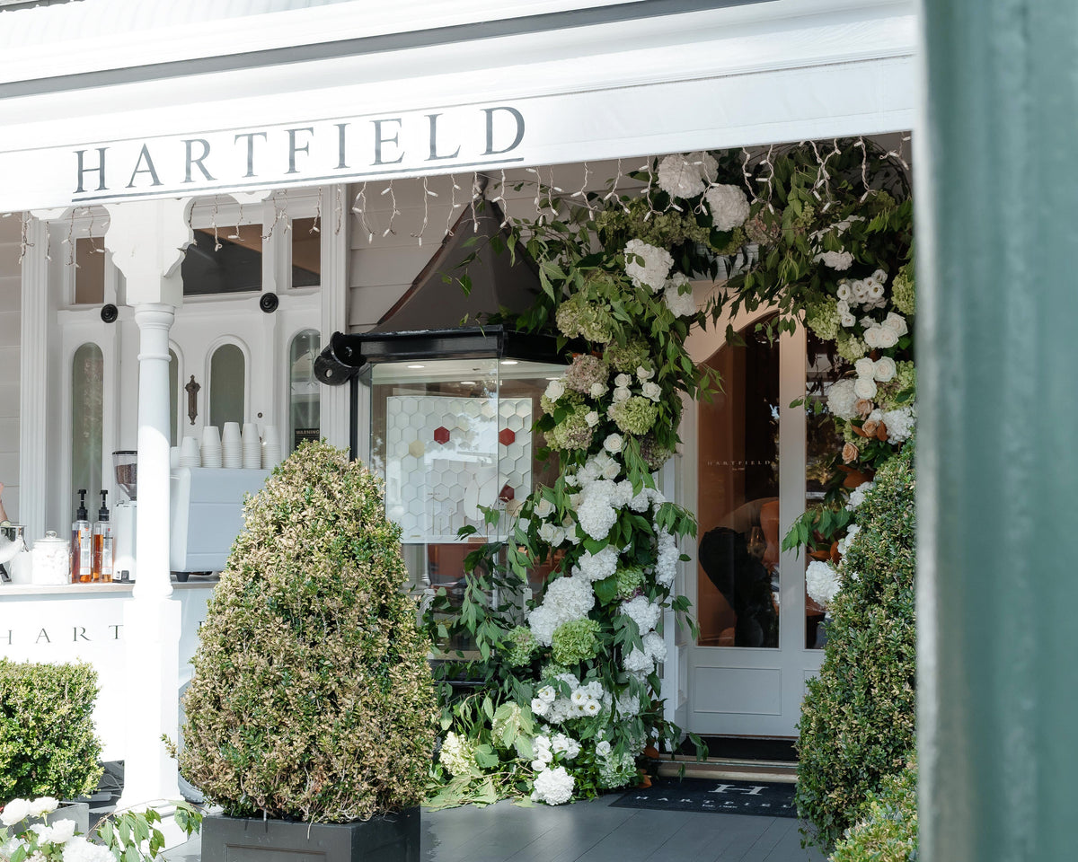 Decorative entrance with floral arrangements and 'Hartfield' sign